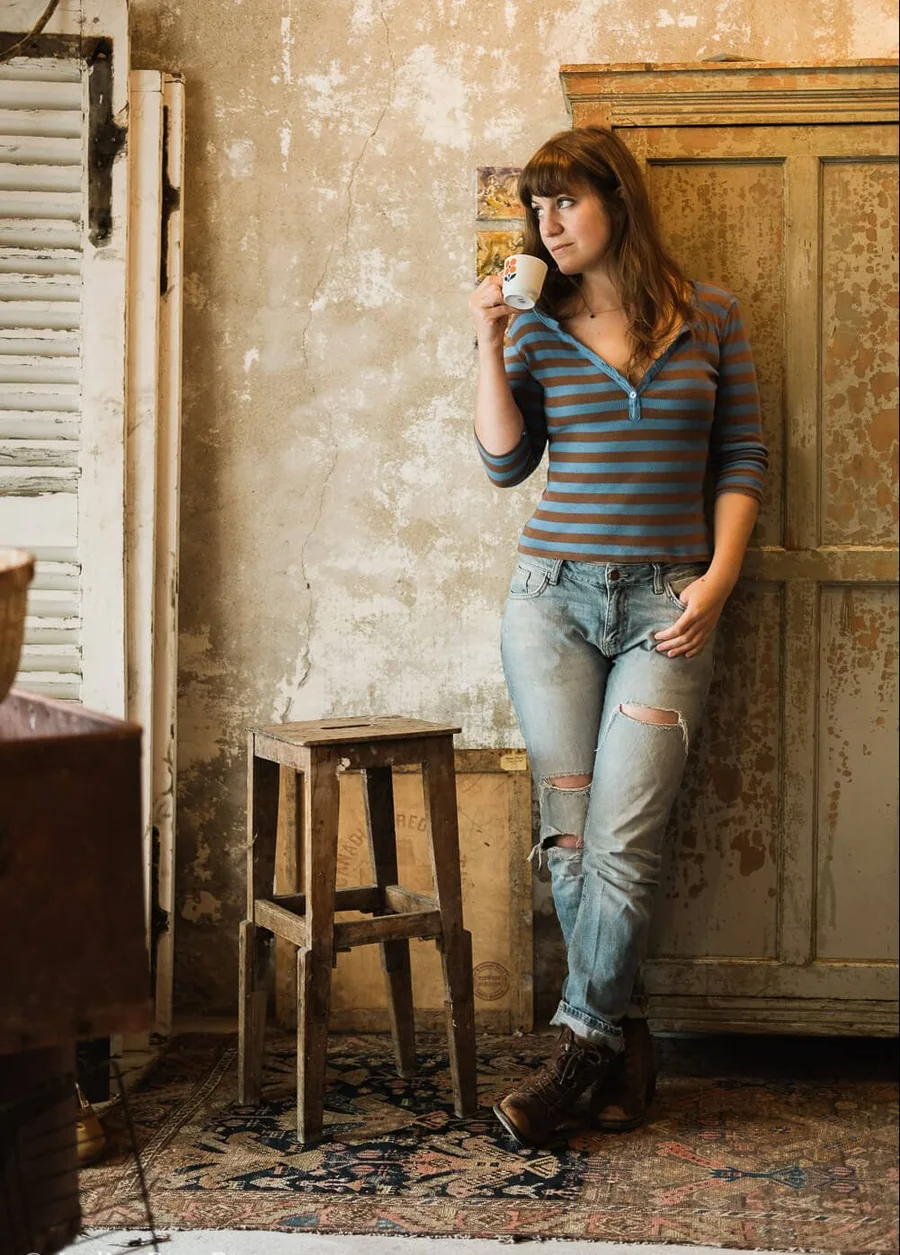 Portrait de Cécile Missol, adossée à une armoire ancienne dans son atelier